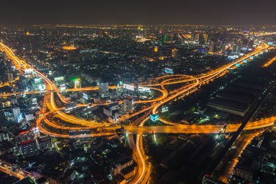 High angle view of illuminated highway amidst buildings in city at night