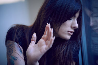 Close-up of worried woman by window