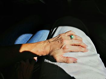 Cropped hand of woman touching man thigh
