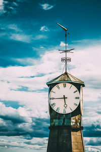 Low angle view of clock tower against cloudy sky