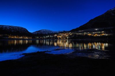 Scenic view of lake against blue sky at night