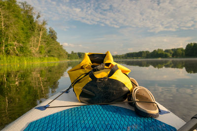 Rear view of man sitting on boat on lake