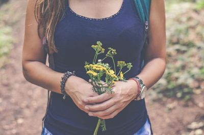 Midsection of woman holding flowers