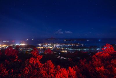 Illuminated city against sky at night