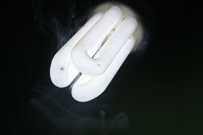 High angle view of illuminated light bulb against black background