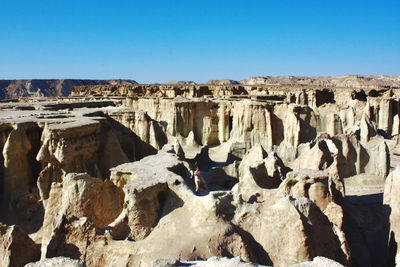 Panoramic view of rocks on landscape against blue sky