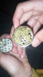 Close-up of hands holding marijuana in grinder