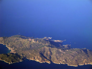 Aerial view of mountains against blue sky