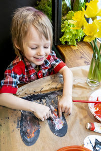 High angle view of cute baby girl painting on table