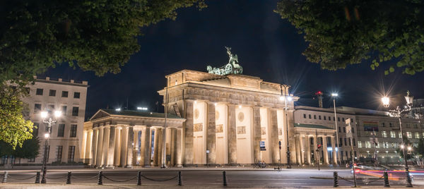 Brandenburg gate at night with a treetop as a frame