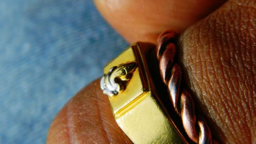 Close-up of ganesha carving on ring wore by person