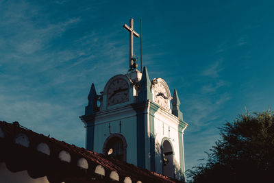 Low angle view of cross on building against sky