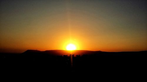 Silhouette landscape against sky during sunset