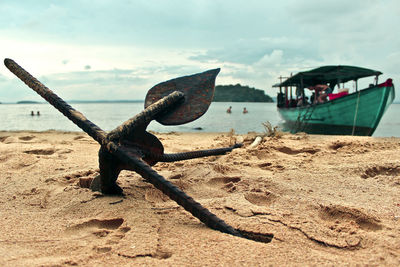 Boats moored on beach against sky