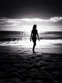 Full length of a silhouette woman walking on beach