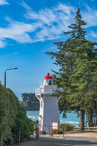 Lighthouse by sea against sky