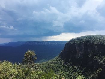 Scenic view of land and mountains against sky