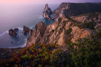 Scenic view of sea and mountains against sky