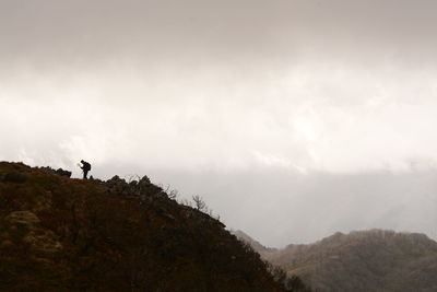 Man standing on mountain against sky