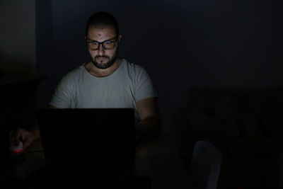 Young man using mobile phone at home