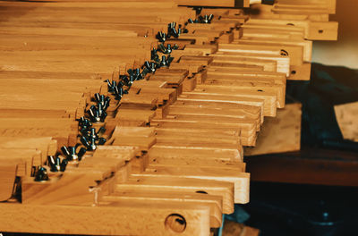 View of wooden legs to easels lying in row. production of easels. woodworking workshop.