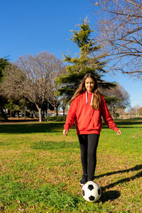 Full length of woman playing soccer at park