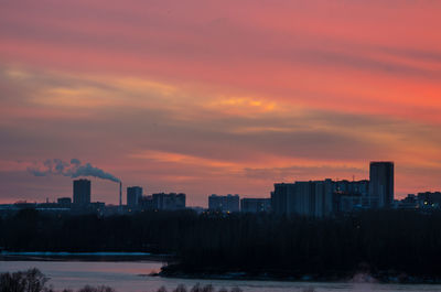 Buildings in city against orange sky