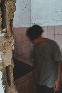 Rear view of man walking against wall