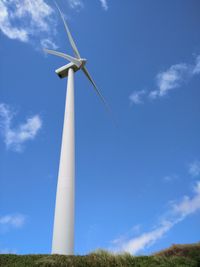 Low angle view of windmill on field against sky