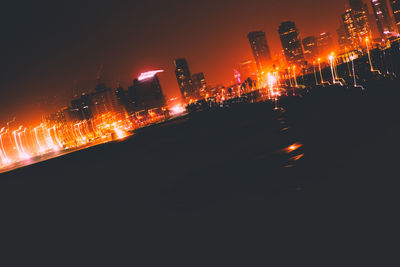 Illuminated city against sky at night