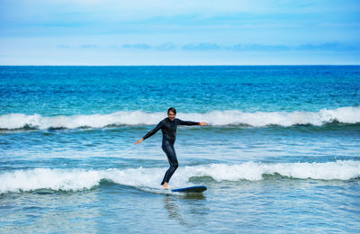 Side view of man surfing in sea against clear sky