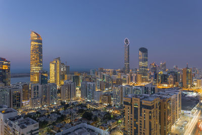 Illuminated buildings in city against sky