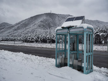 Built structure on snow covered field against sky