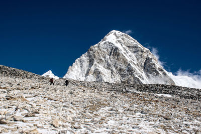 Low angle view of snowcapped mountain against blue sky