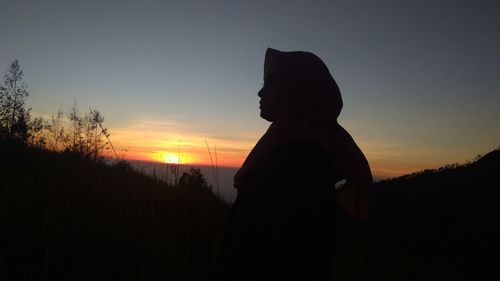 Silhouette man standing against sky during sunset