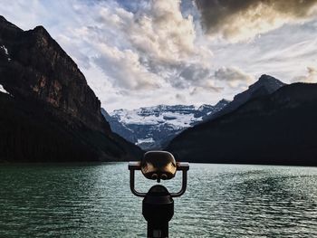 Coin-operated binoculars against lake and mountains