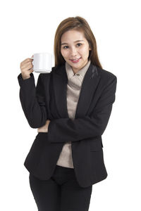 Portrait of young woman drinking coffee cup against white background