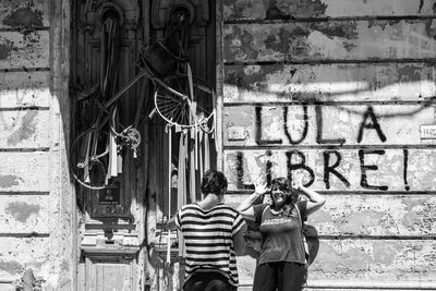 Rear view of people standing against wall