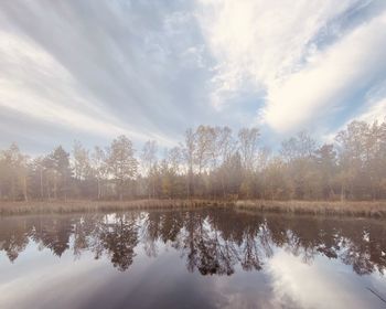 Scenic view of lake by trees against sky