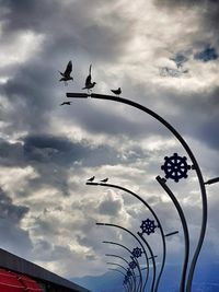 Low angle view of silhouette birds flying against sky