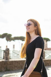 Happy woman walking in city in summer day