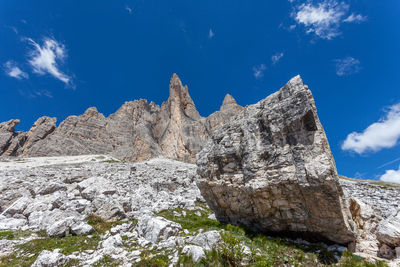 Low angle view of rocks against blue sky