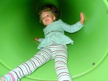 Portrait of girl enjoying in green slide