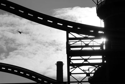 Low angle view of silhouette bridge against sky