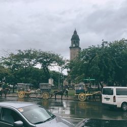 Cars on road against sky in rain