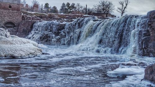 View of waterfall against sky during winter