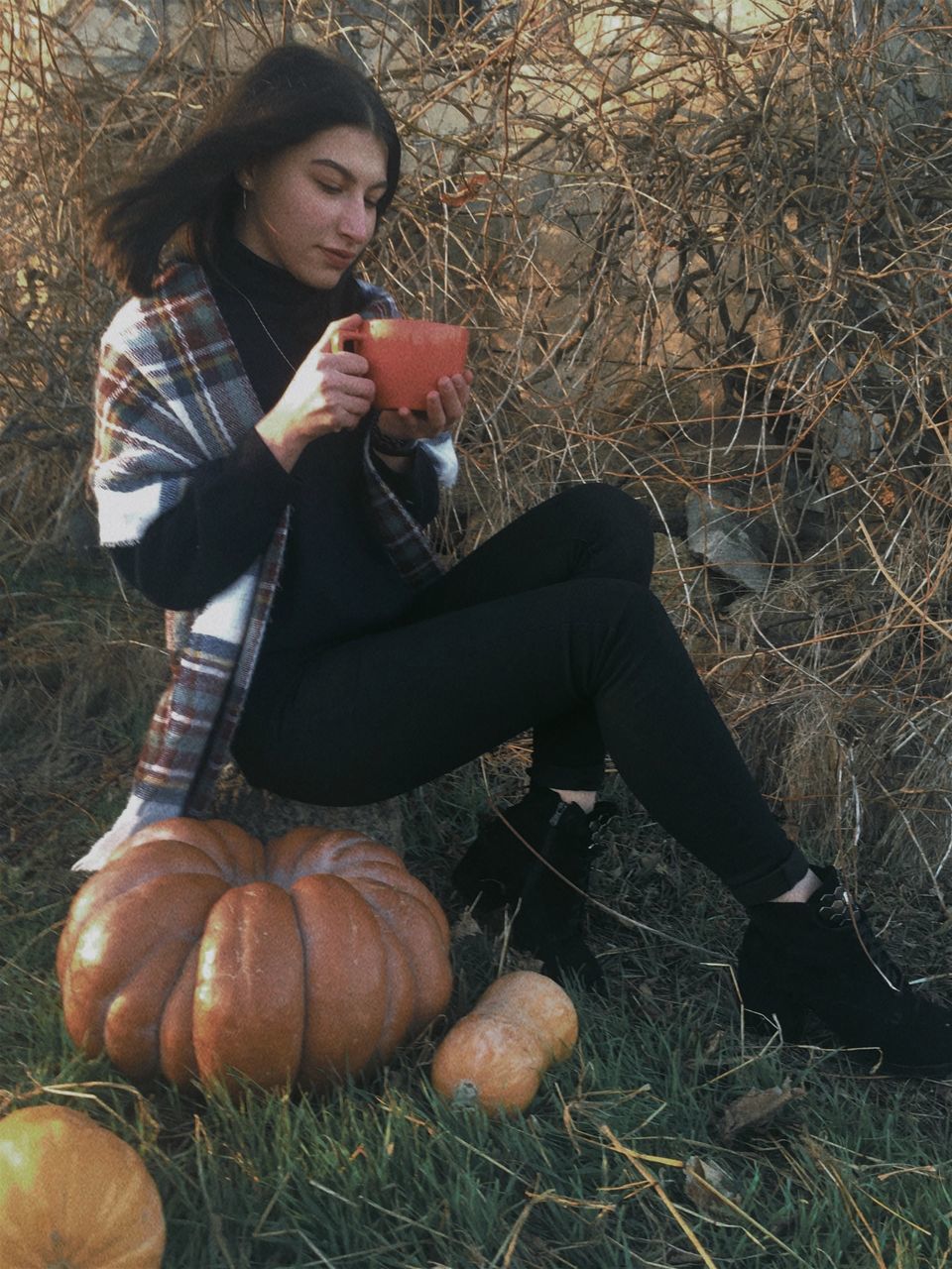 one person, autumn, food and drink, full length, sitting, plant, holding, young adult, women, food, adult, nature, casual clothing, leisure activity, pumpkin, lifestyles, person, long hair, tree, human leg, hairstyle, looking, grass, spring, clothing, brown hair, land, outdoors, day, footwear, front view, squash, field, relaxation, female, vegetable, healthy eating, wellbeing, human hair