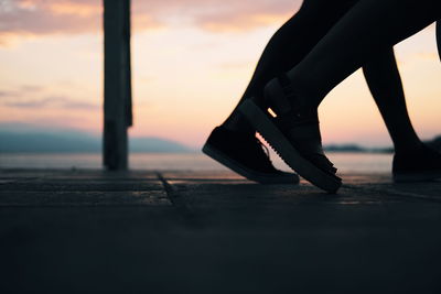 Low section of people walking at dusk