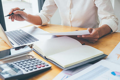 Midsection of man using laptop on table