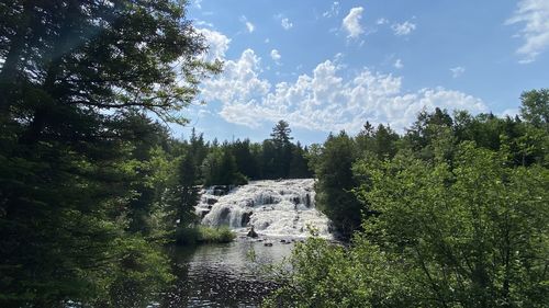 Scenic view of waterfall against sky